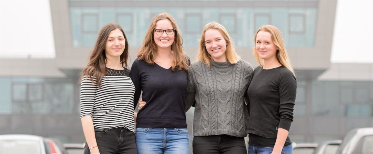 Vier junge Frauen stehen Arm in Arm vor dem ZAL TechCenter